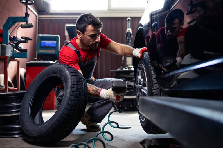 Wheel repairman removing damaged tire from car
